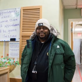 SFH Guest A guest dressed in winter clothing stands in our clothing center, smiling.