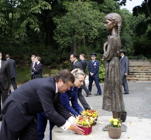 U.S. Secretary of State Clinton and Ukraine's Foreign Minister Gryshchenko take part in a wreath laying ceremony at a monument to Holodomor victims in Kiev
