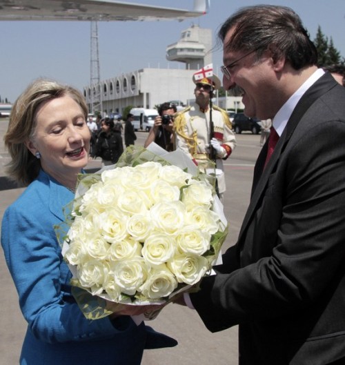 Georgia's Foreign Minister Vashadze presents a bunch of flowers to U.S. Secretary of State Clinton upon her arrival at Tbilisi airport