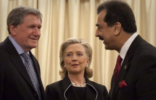 U.S. Secretary of State Clinton watches as Pakistan's PM Yusuf Raza Gilani meets her delegation in Islamabad