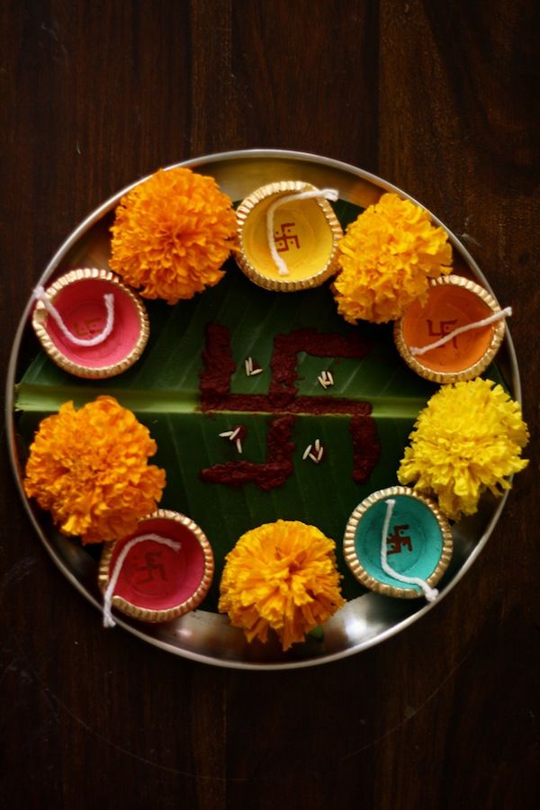 A plate decorated with Diya's and Marigold Flowes for Aarti.