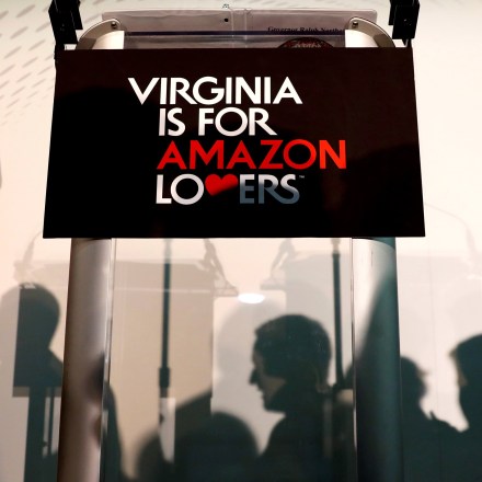 People move about in front of the rostrum before a news conference about the announcement that Crystal City has been selected as home to Amazon's new headquarters in Arlington, Virginia, U.S., November 13, 2018. REUTERS/Kevin Lamarque - RC1CBF088580