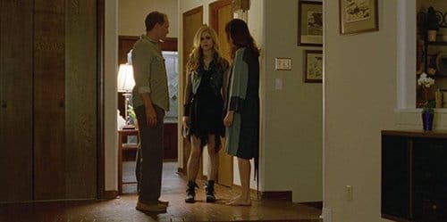 Audrey dressed in black with makeup on her face. In this scene, she got caught by her father having sex with two guys in a truck.