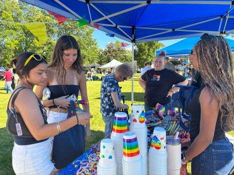 DST-L-HOMEWOOD-PRIDE-0614-02 Layla Esparza and Mia Caldanero look through rainbow bracelets and handkerchiefs at Homewood-Flossmoor Pride Fest at Flossmoor Park. (Evy Lewis/Daily Southtown)