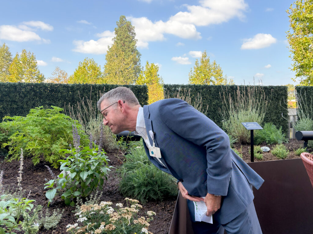 Man smelling a plant.