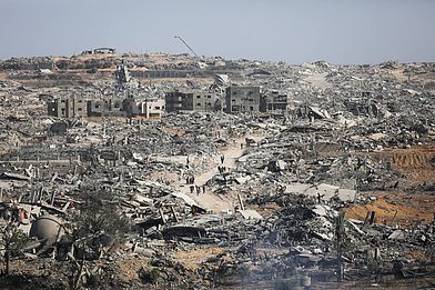 Menschen laufen durch eine Trümmerlandschaft in Gaza.