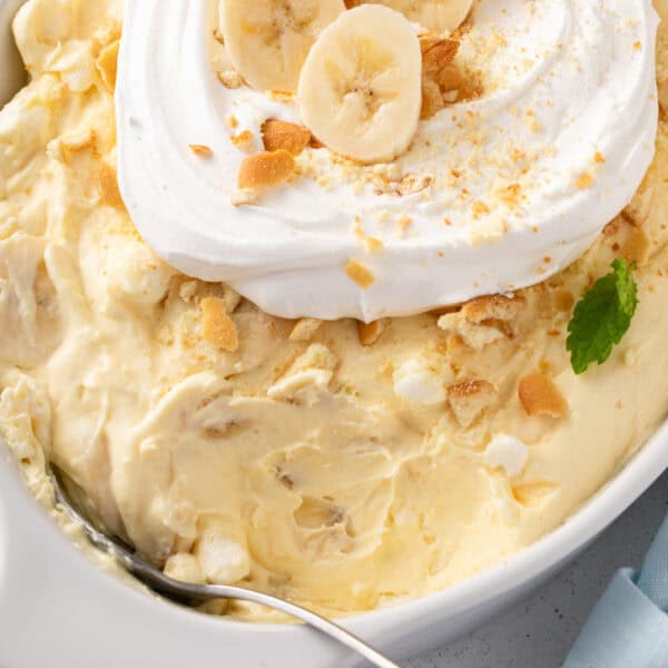 Serving spoon in a white dish of banana pudding fluff.