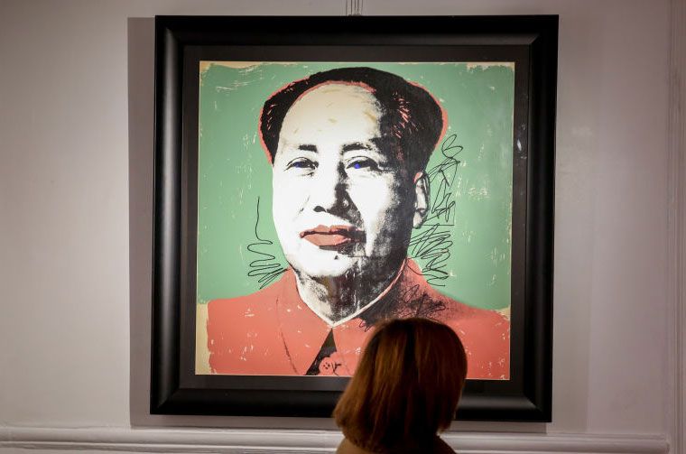 Une femme devant un portrait de Mao Tse Tung, lors de l'inauguration de l'exposition "ANDY WARHOL SUPER POP"2022 à Madrid.
