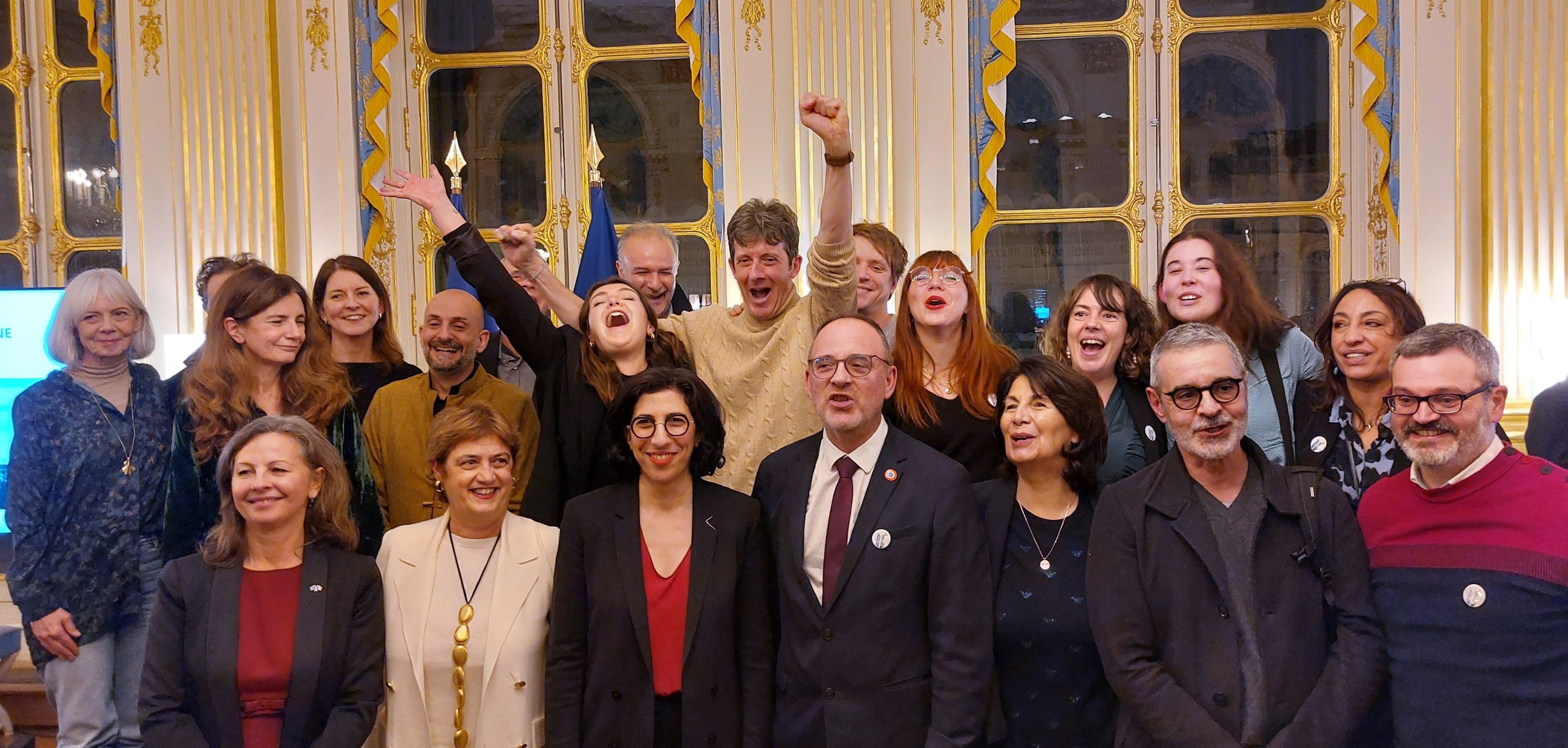 La ministre de la Culture Rima Abdul Malak avec à sa gauche le maire PS Yann Galut et d’autre membres de la délégation de Bourges dont le commissaire général de la candidature Pascal Keiser, avec un bras levé en signe de victoire.