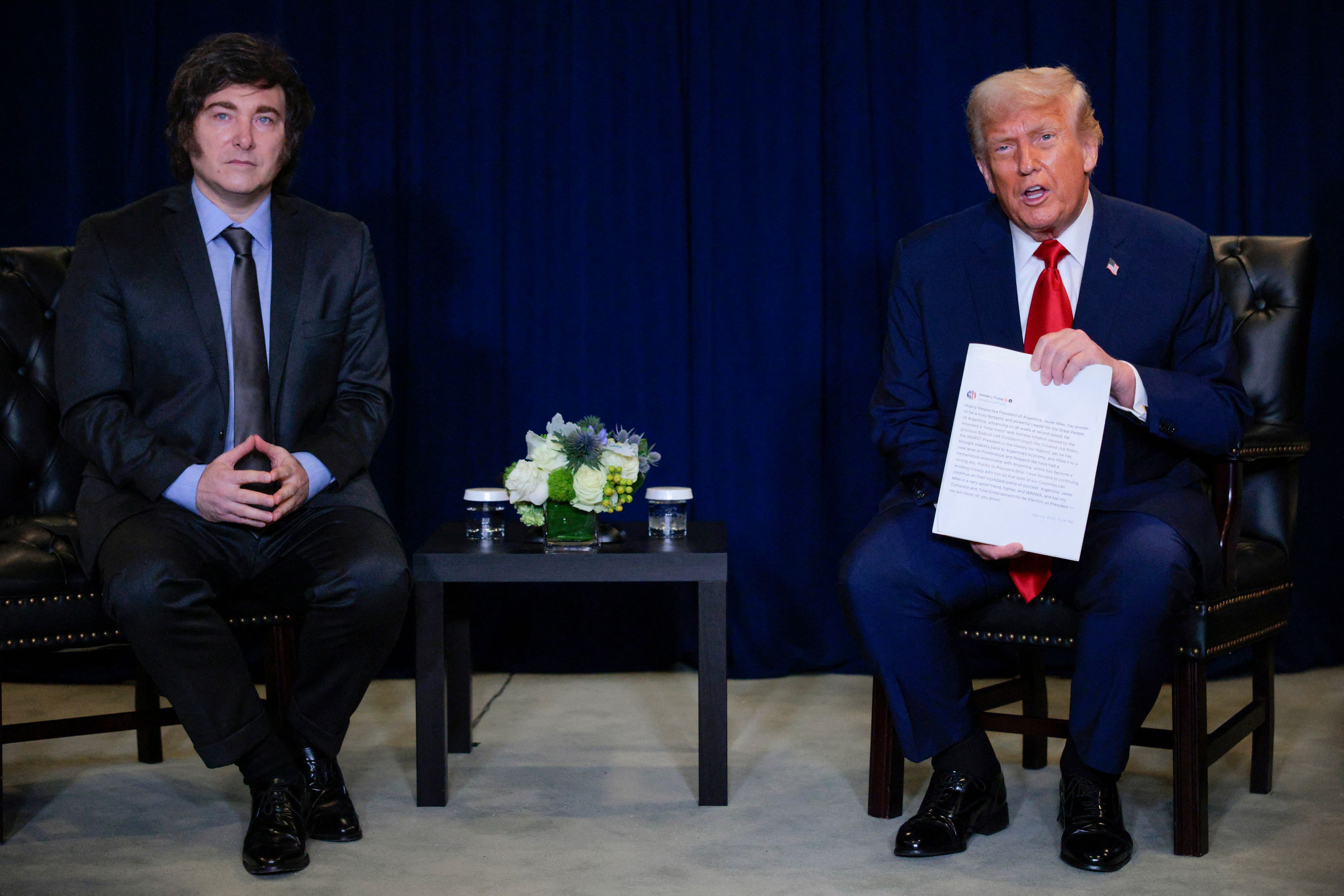 Le président américain Donald Trump tient une copie imprimée de sa publication sur les réseaux sociaux alors qu'il s'entretient avec le président argentin Javier Milei lors d'une réunion bilatérale à la 80e session de l'Assemblée générale des Nations Unies (AGNU) au siège des Nations unies, le 23 septembre 2025 à New York.
