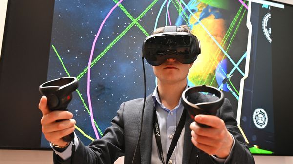 Lors du salon Space-Comm à Londres, le 11 mars 2025, un exposant présente la plateforme d'expérience 3D de Dassault Systèmes.