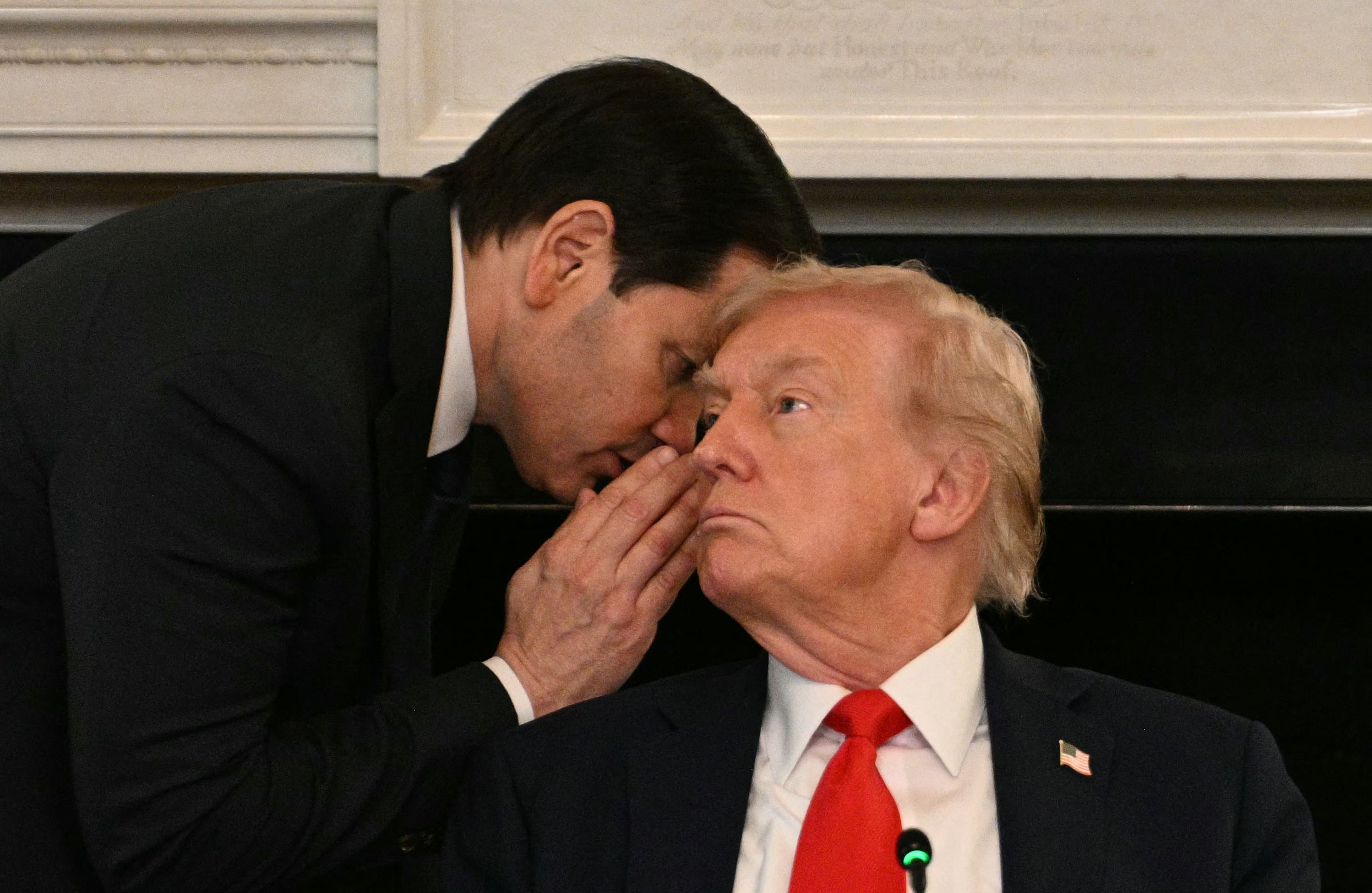 Le secrétaire d'État américain Marco Rubio chuchote à l'oreille du président Donald Trump lors d'une table ronde dans la salle à manger d'État de la Maison Blanche à Washington, DC, le 8 octobre 2025.