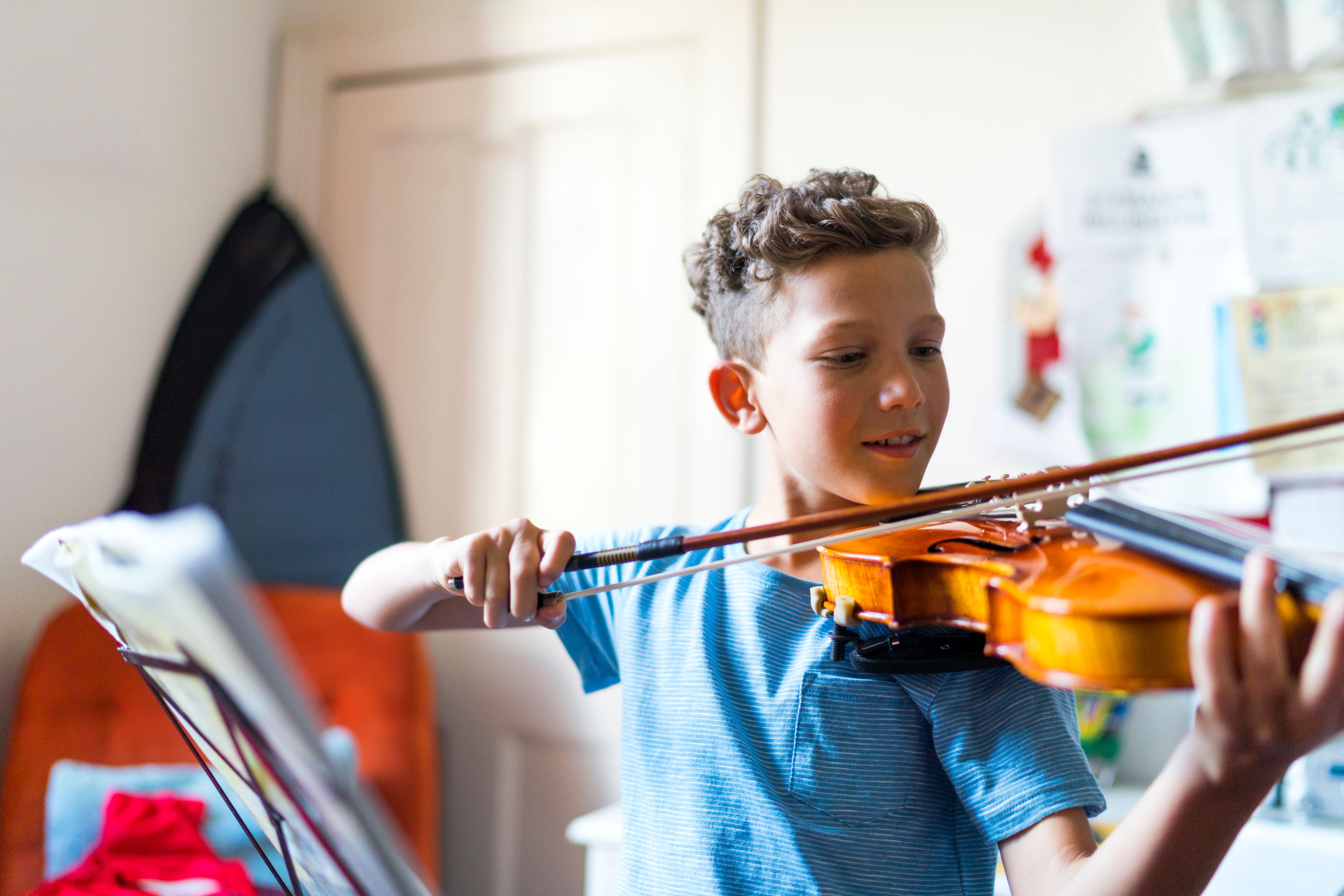Un enfant jouant du violon chez lui