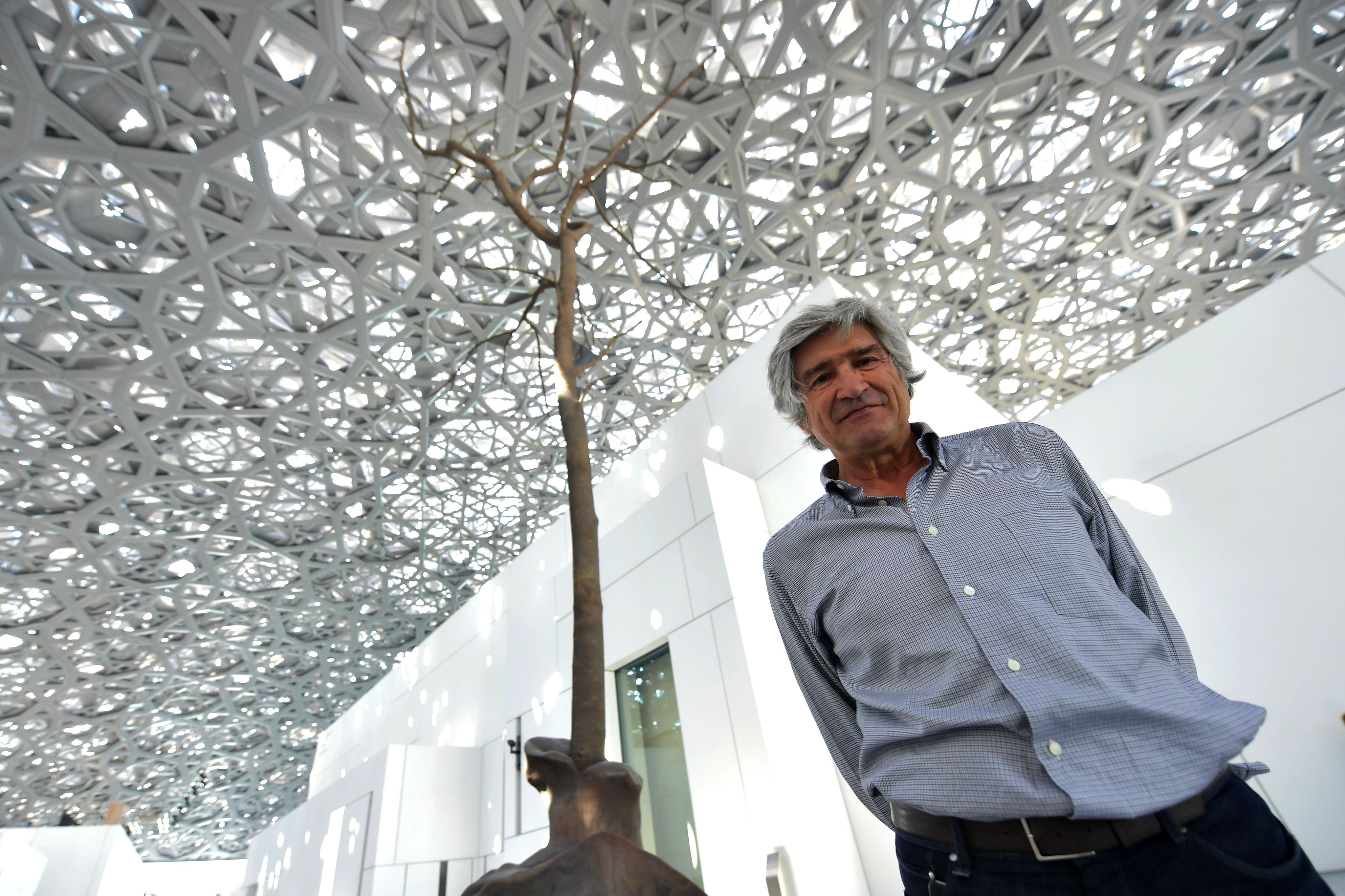 Giuseppe Penone au côté de sa sculpture "Germination" au Louvre Abu Dhabi en 2017