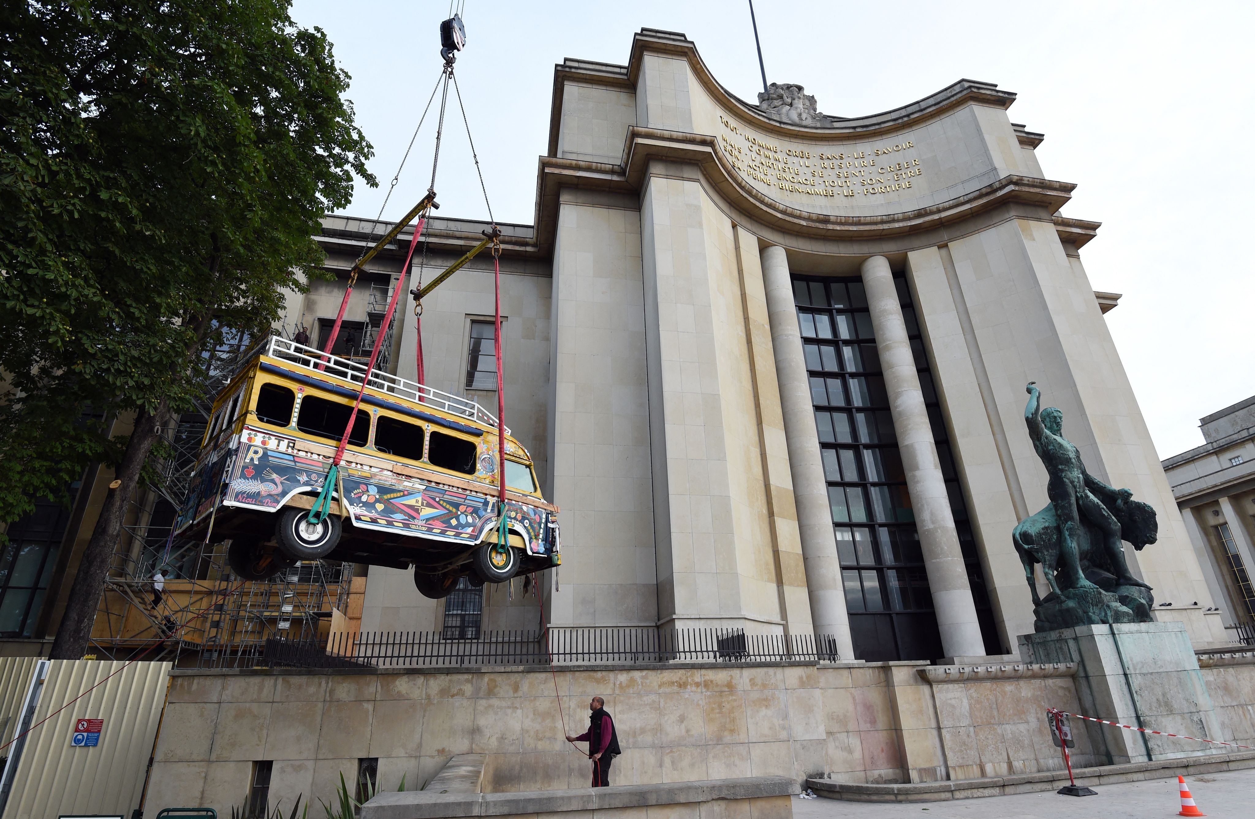 Un bus sénégalais, également appelé « car rapide », est hissé par une grue jusqu'au Musée de l'Homme pour une exposition en juillet 2015 à Paris.