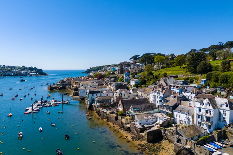 Aerial view of the village of Fowey, Cornwall, UK, on a clear day with boats in the Fowey River.