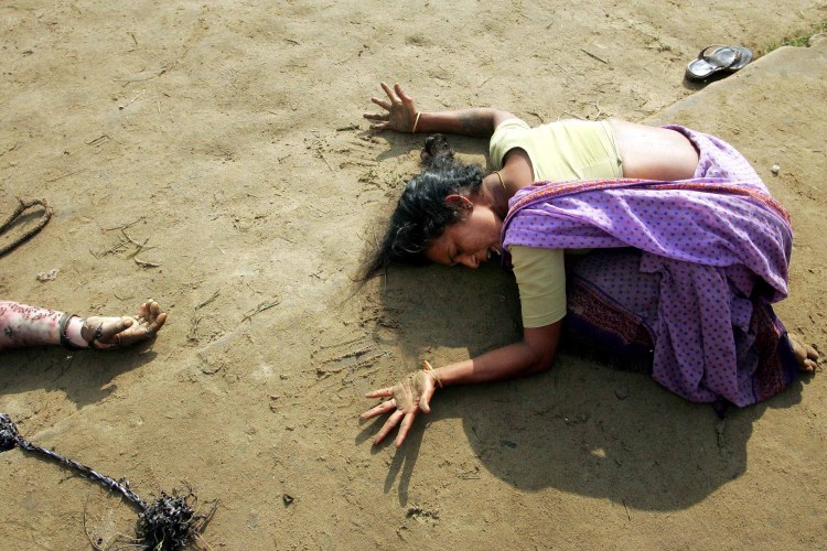 Woman mourning near the body of a tsunami victim.
