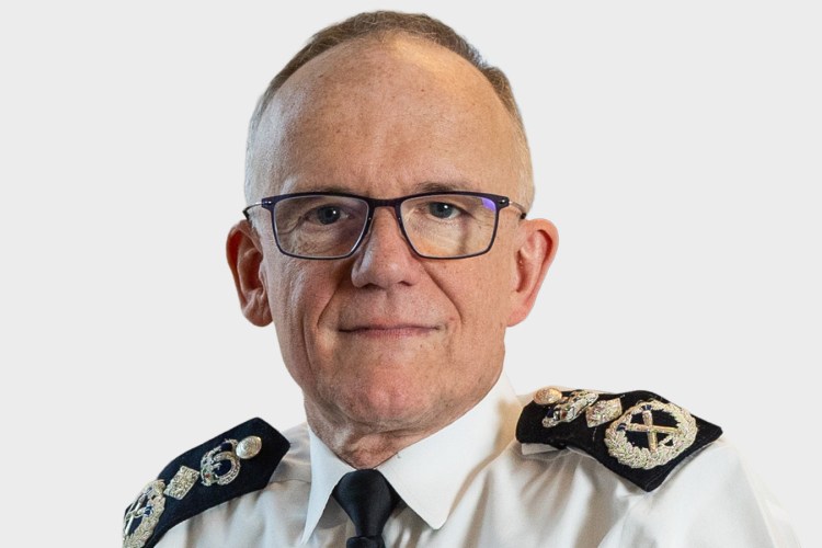 Headshot of Mark Rowley, former Chief Constable of Surrey Police, wearing a white shirt with epaulets and a black tie.