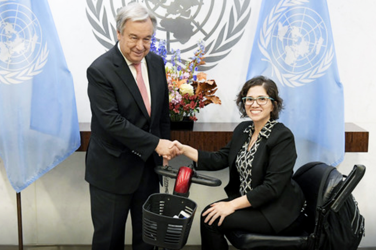 More action is needed to dismantle both ageism and ableism. UN Secretary-General stands between two UN flags and shakes hands with Ms. Catalina Devandas Aguilar, who is sitting in a wheelchair.