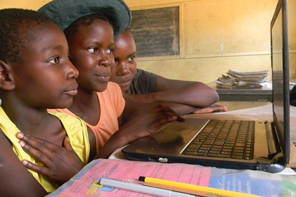 UNESCO data shows that 43% of the world’s households do not have access to the internet. Three boys in front of a laptop.
