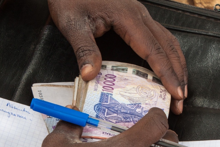 Secretary-General's policy briefs on the COVID-19 pandemic person's hands holding currency