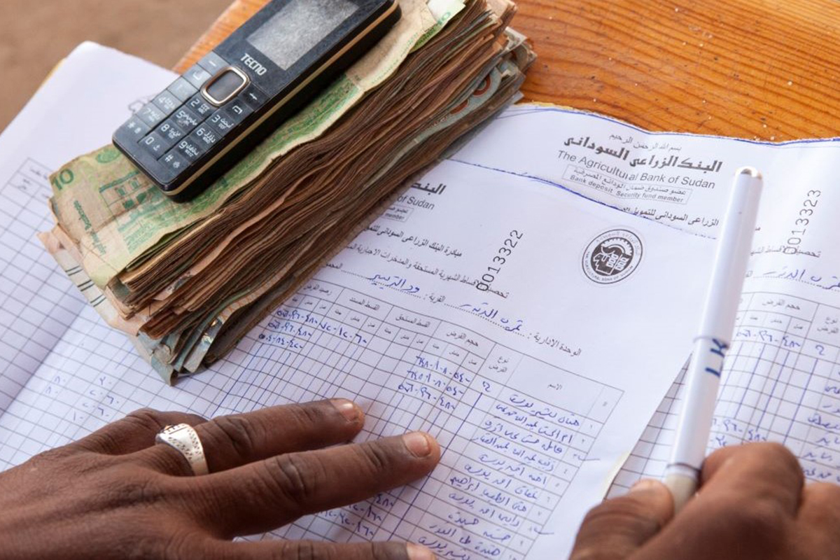 Nearly all the world’s countries committed to nationally-determined contributions (NDCs) towards meeting the goals of the Paris Agreement. Photo: IFAD Hands on a paper spreadsheet with currency and a calculator near by.