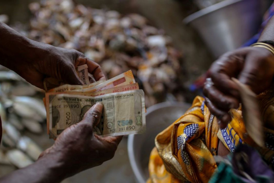 A staggering one billion people worldwide – that’s about one in seven – are involved with remittances. Image: IFAD hands counting money