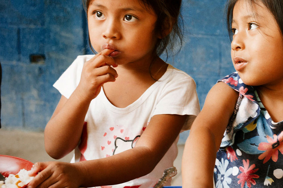 Food prices have been up by half since 2019 and supply disruptions have persisted in both food and energy markets. Photo: FAO / Pep Bonet two girls eating