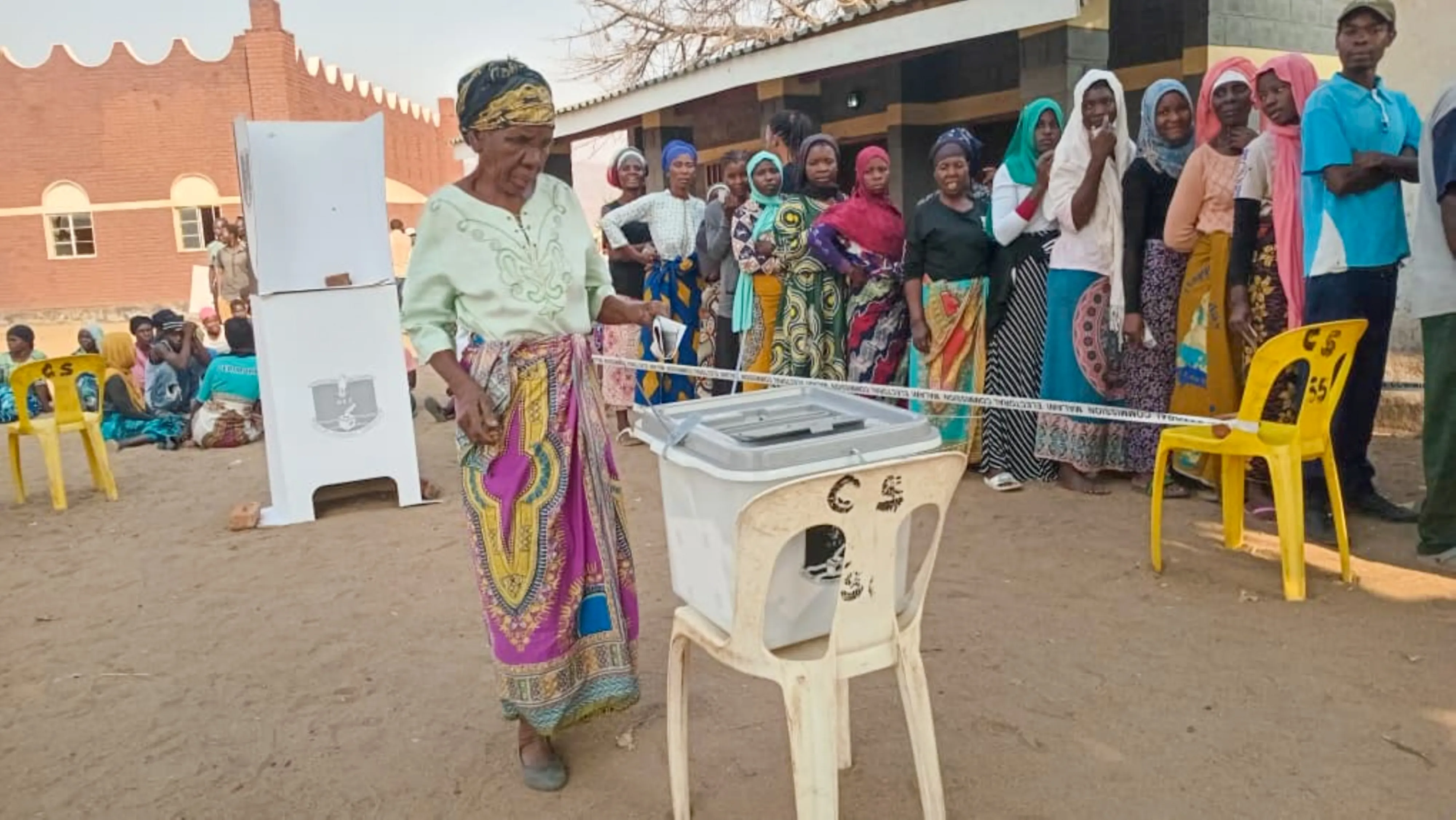 A photograph showing a woman placing a ballot