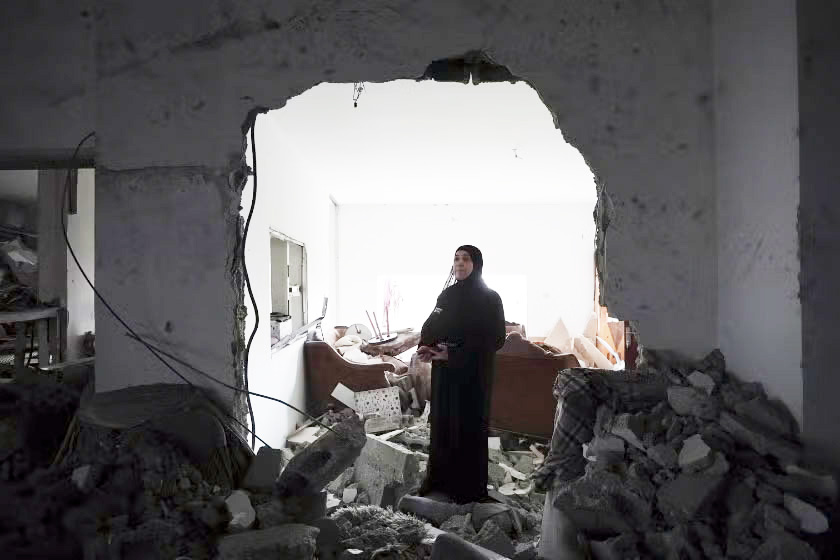 A woman standing in her house which has been destroyed by the ongoing conflict in West Bank.