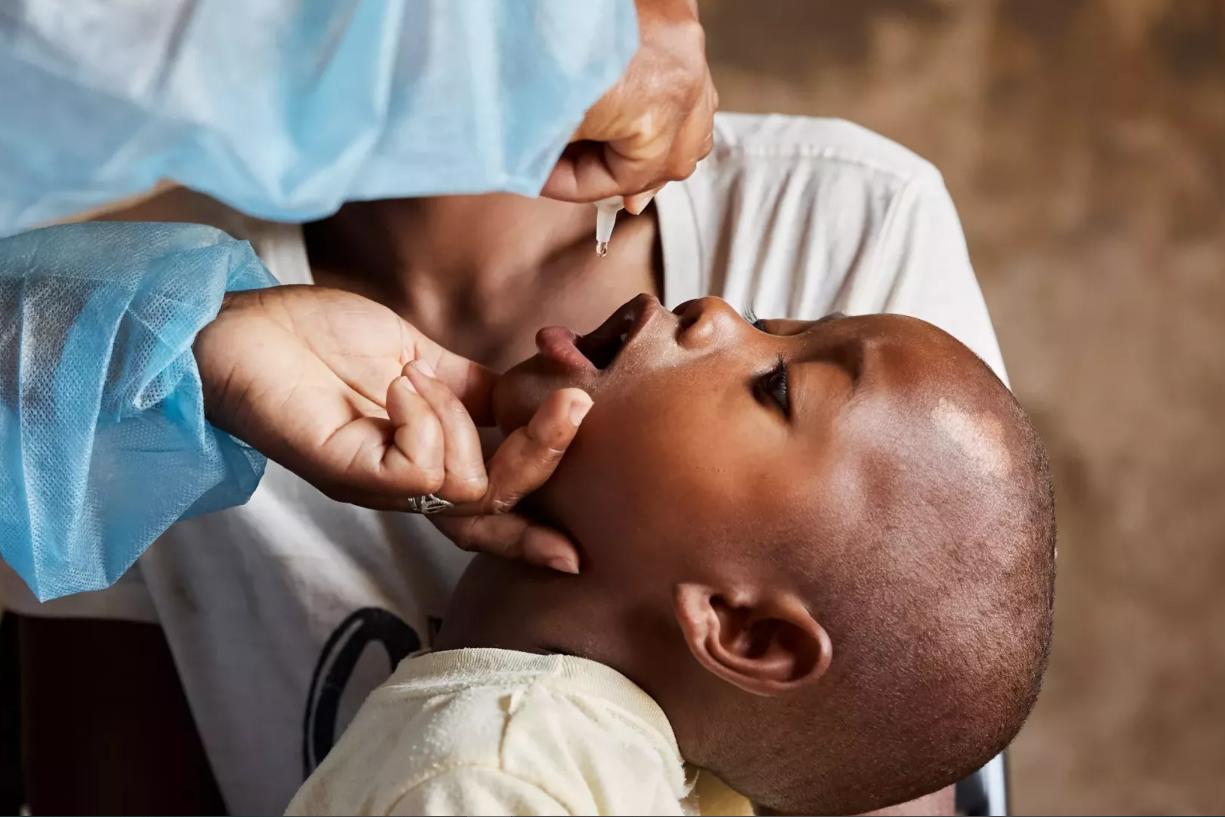 A baby receiving a vaccine orally.