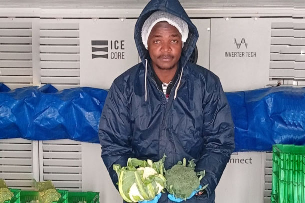 A farmer holding his produce in a refrigerated truck.