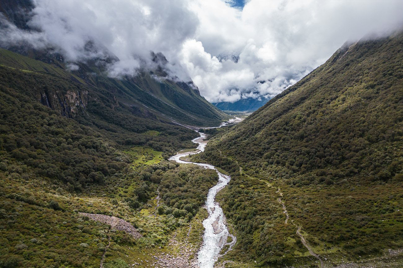 A stunning mountainous landscape with a winding river cutting through a lush green valley.