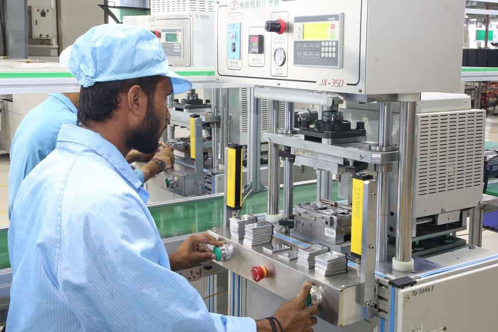 A man at a factory operating a machine.