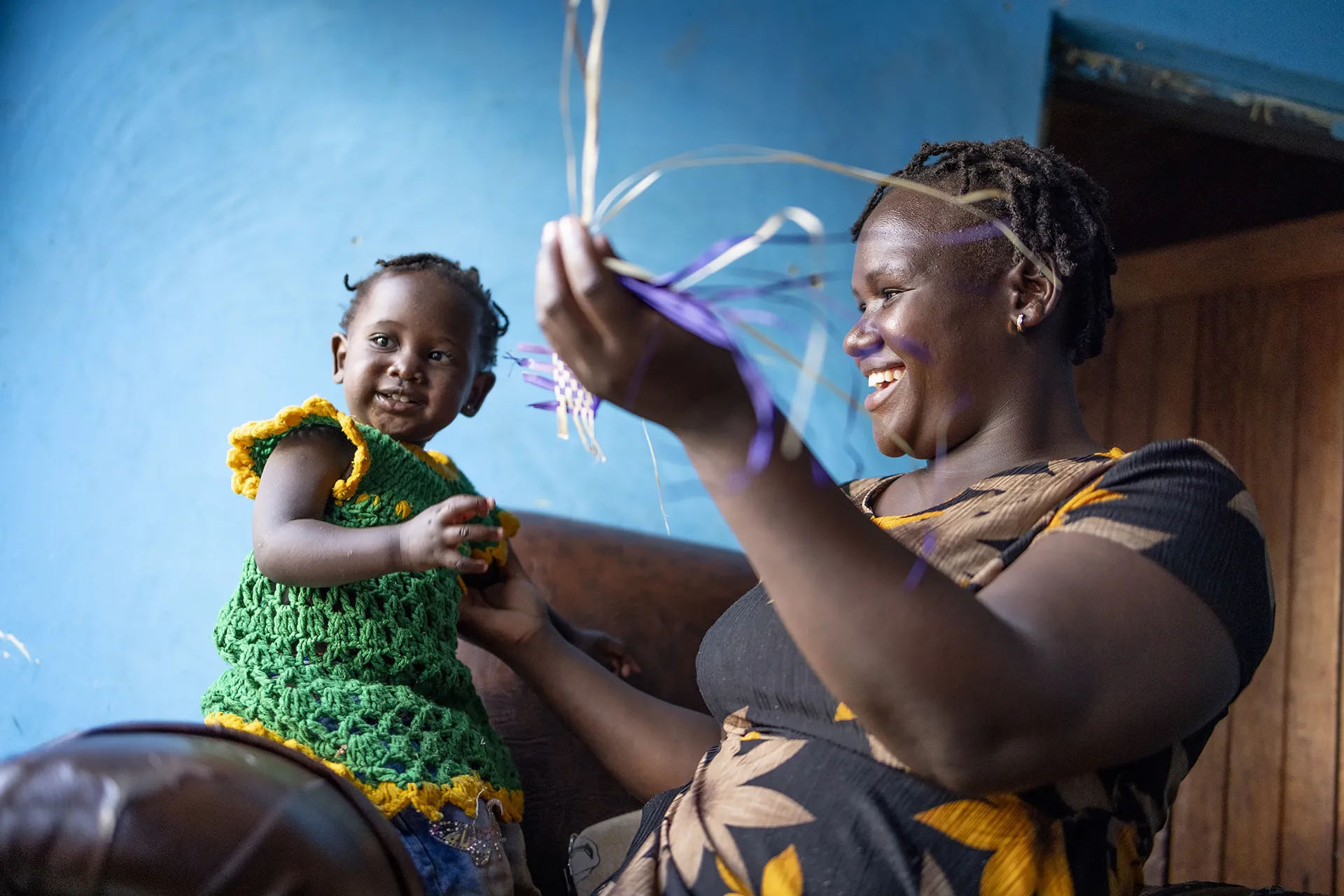 woman showing plastic braiding with little girl