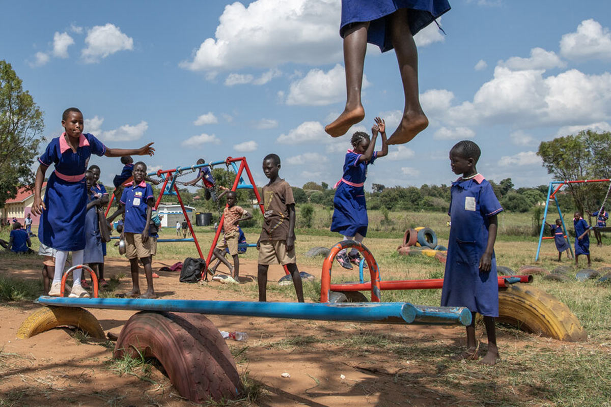 children in school uniform are playing in a playground