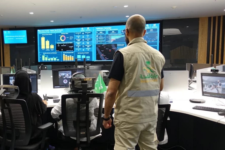 A couple of technicians looking at digital screens.