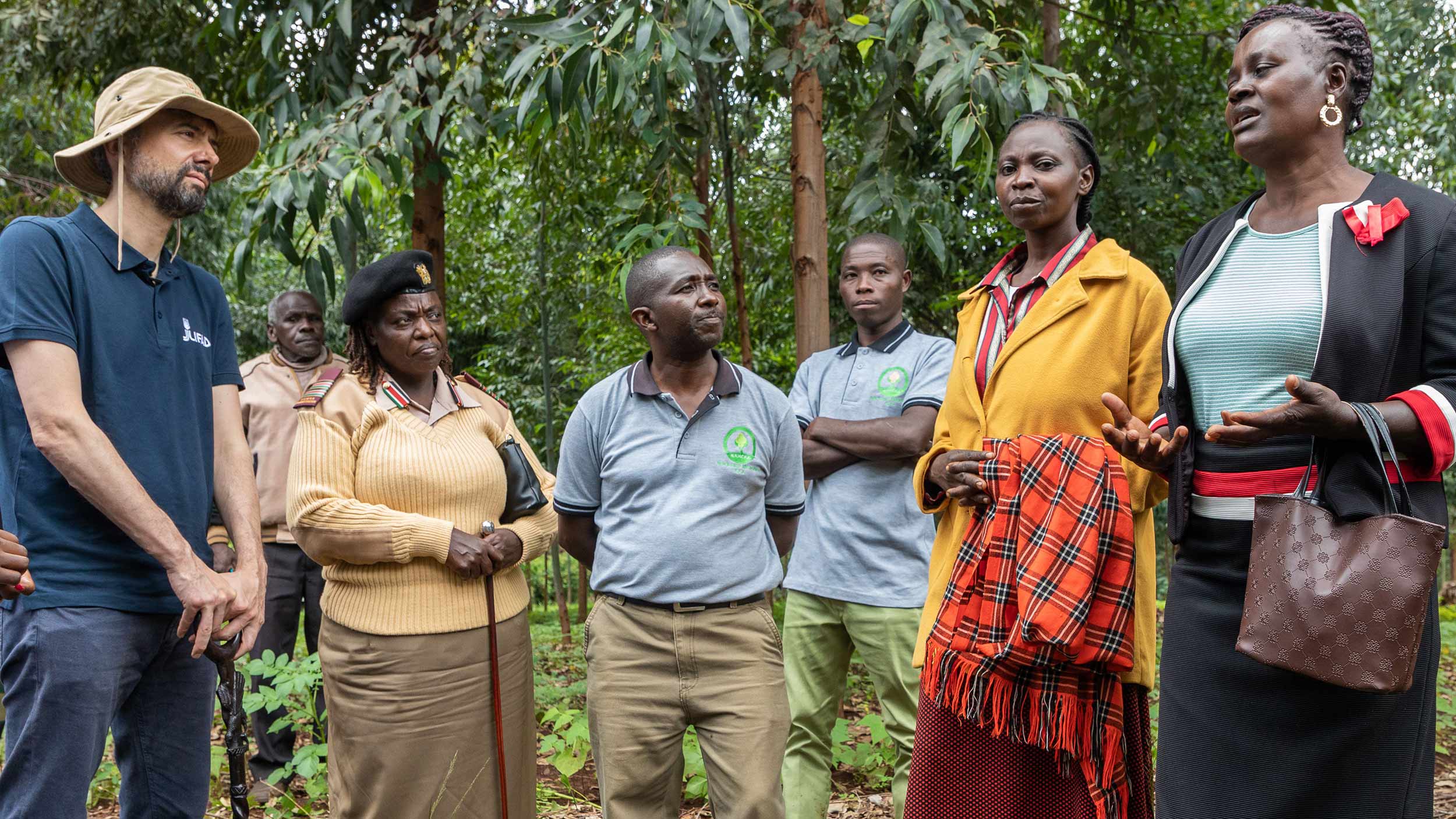 Alvaro is with three men and three women in a dense tree space looking at each other and talking