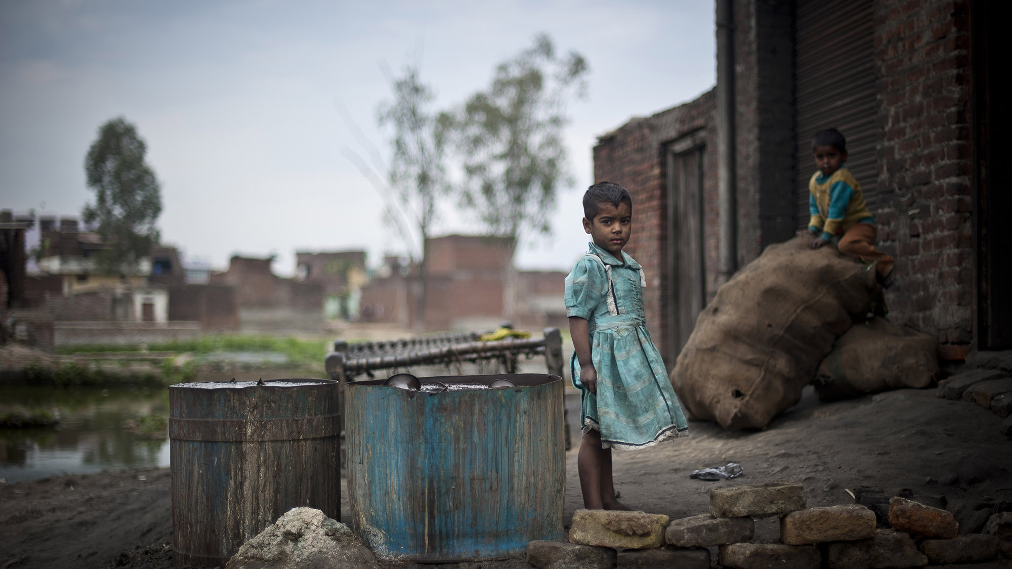 Children play outside a metal polishing work-shop in Uttar Pradesh, India.