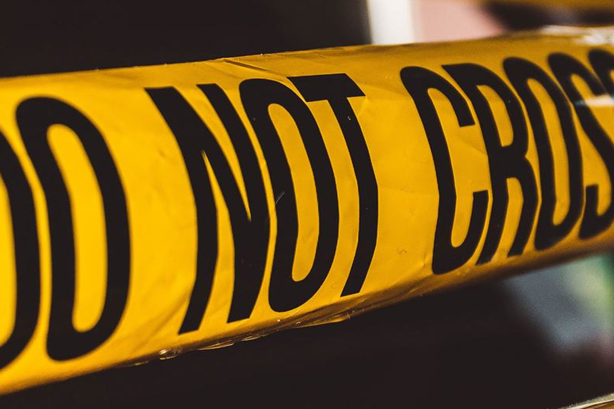 A photograph showing a closeup of yellow and black ‘DO NOT CROSS’ tape