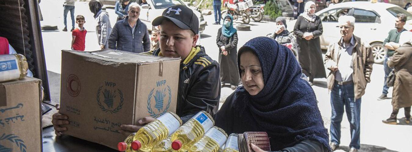 Una familia en Siria recoge su asignación mensual de alimentos.