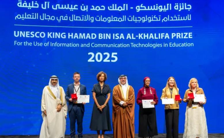 Winners of the UNESCO King Hamad bin Isa Al-Khalifa Prize on stage with their trophies.
