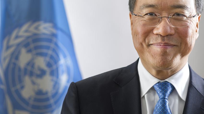 United Nations Messenger of Peace Yo-Yo Ma Portrait of Yo-Yo Ma in UN studio with Blue UN flag in back